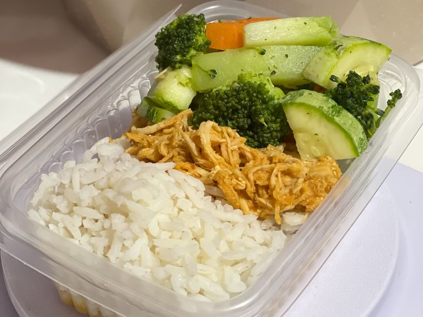 A nutritious meal prep box with rice, shredded chicken, and mixed vegetables.